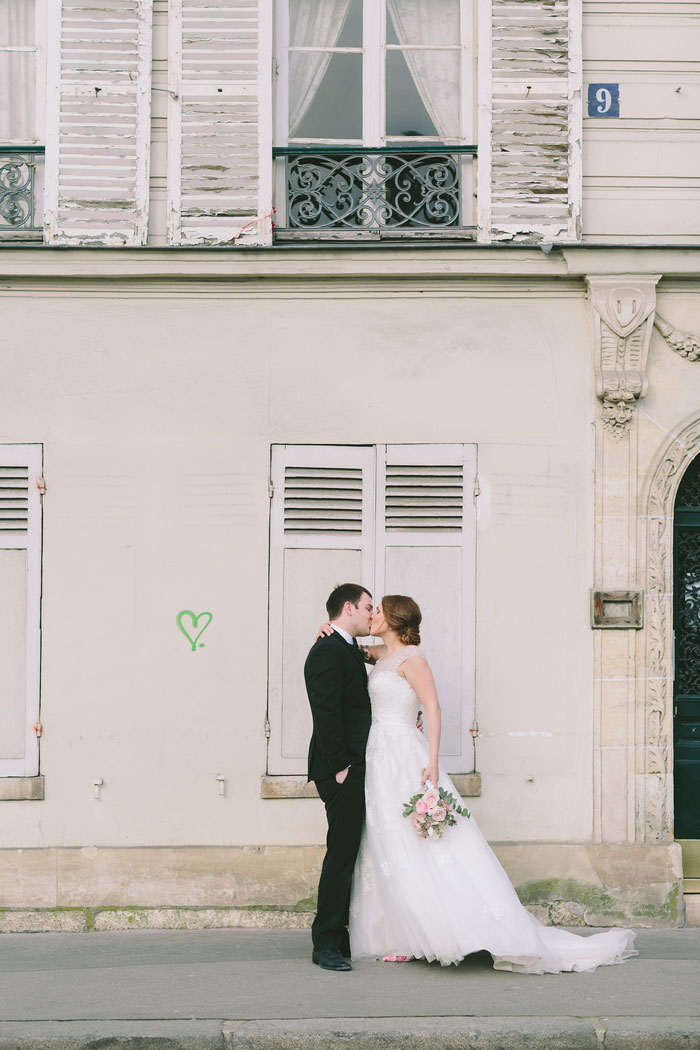 bride and groom kissing in front of heart graffiti 