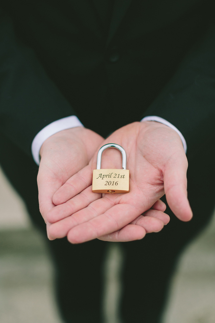 groom holding wedding lock