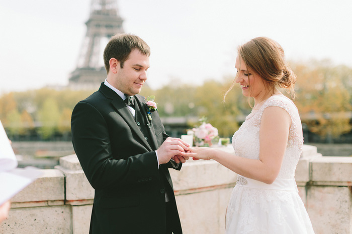 groom putting ring on brides finger