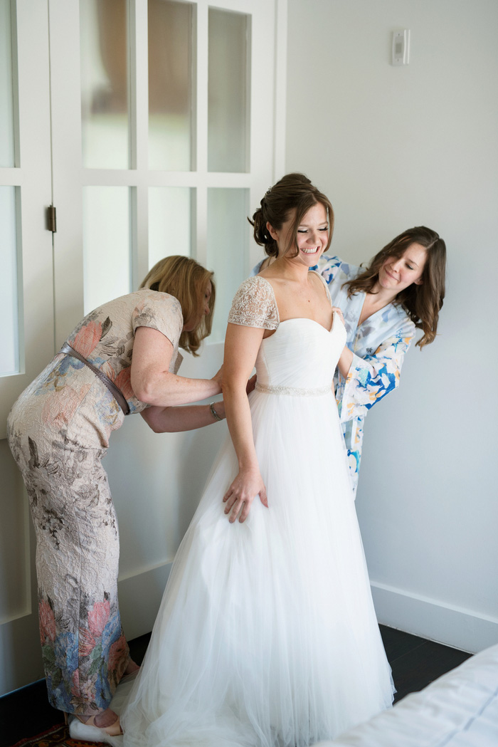 bride getting help getting dressed