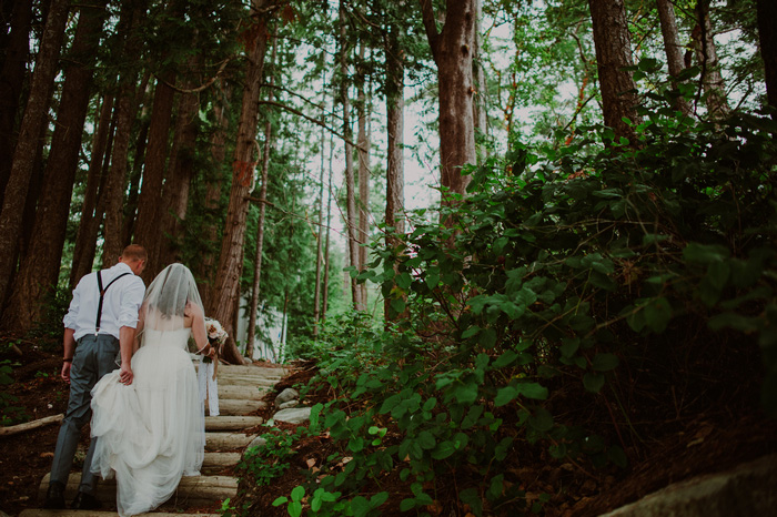 bride and groom climbing steps in the woods