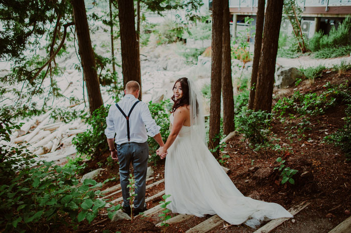 bride looking behind walking down steps in the woods