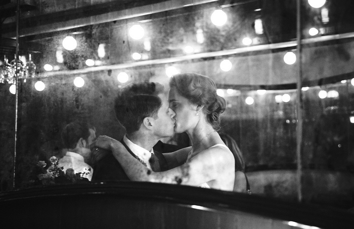reflection of bride and groom kissing