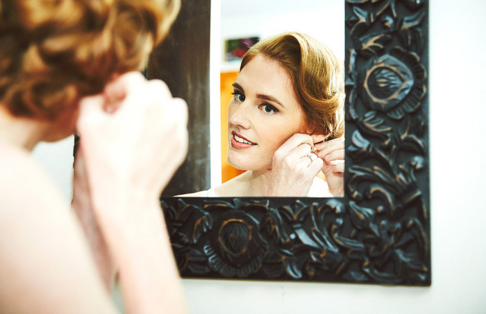 bride putting on earrings