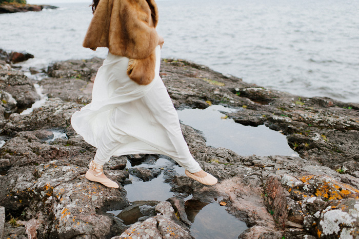 bride stepping across rocks