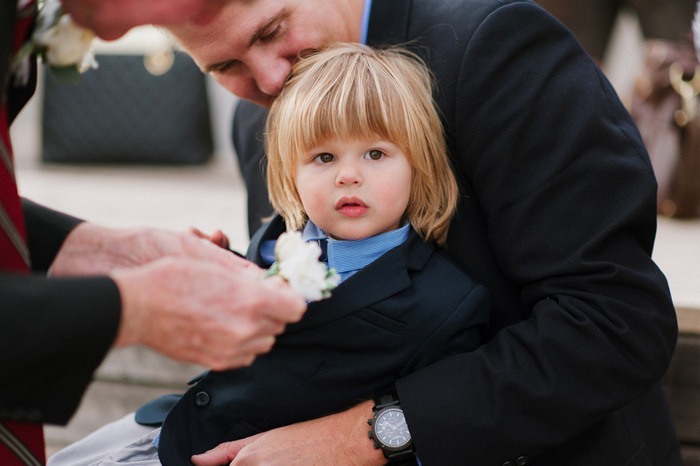 little boy getting boutonniere pinned on