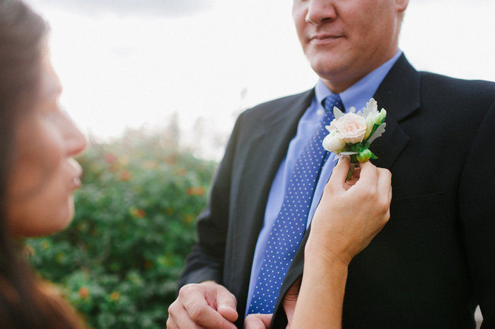 groom geting boutonniere pinned on