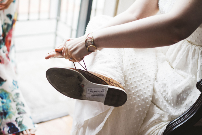 bride lacing up her shoes