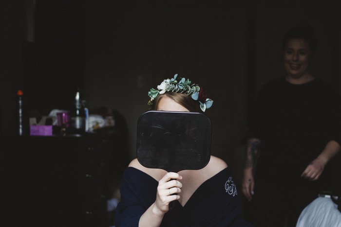 bride hidden behind hand mirror