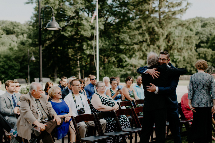 groom hugging guest at ceremony