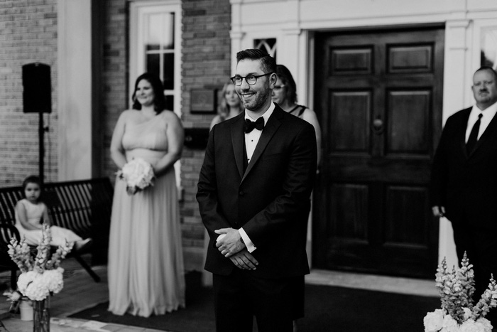 groom watching bride walk up the aisle