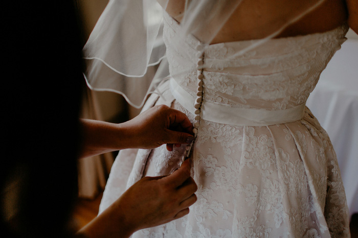 bride's dress being buttoned