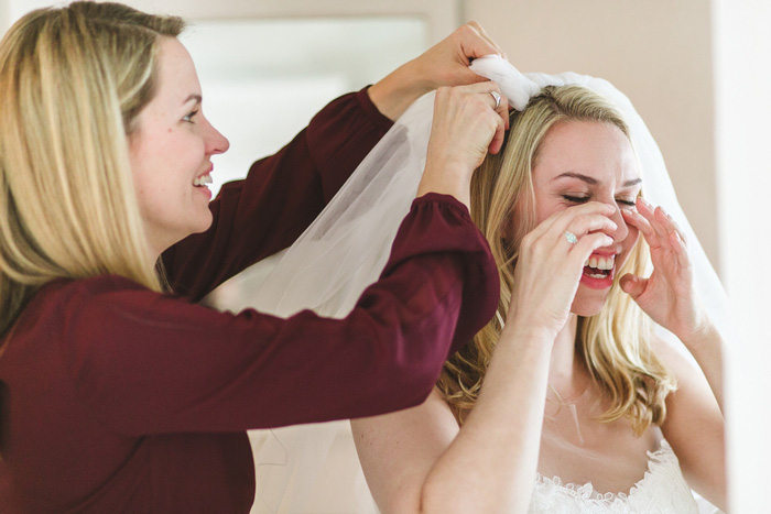 bride wiping away tears as her veil is put on