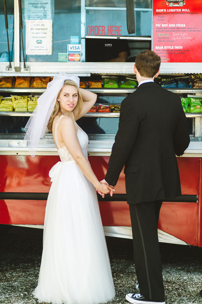 bride and groom standing in front of food truck