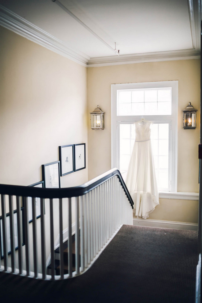 wedding dress hanging in front of window