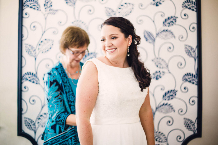 bride getting her dress buttoned up