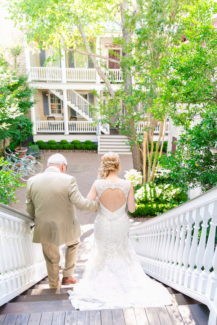 bride waking down outdoor stairs with father