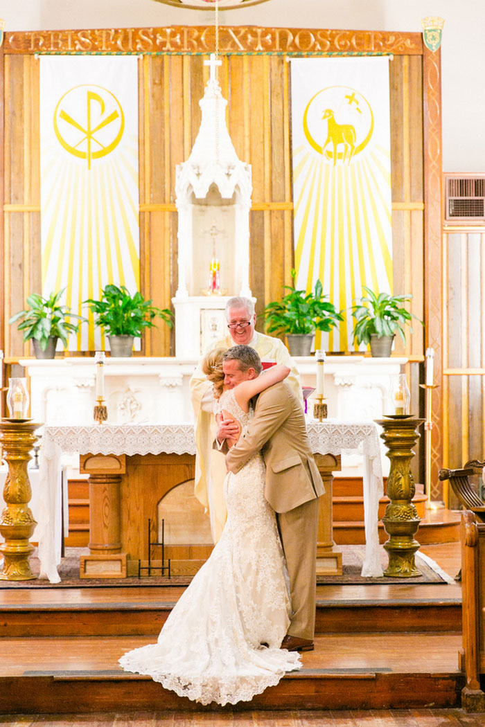 bride and groom hugging at the altar