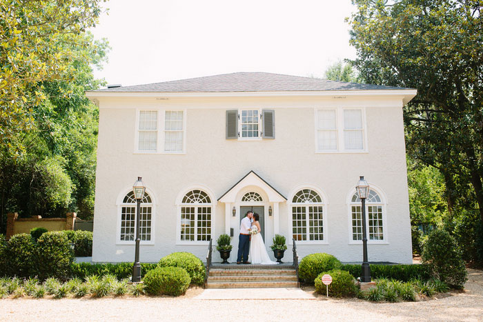 bride and groom portrait in front of house