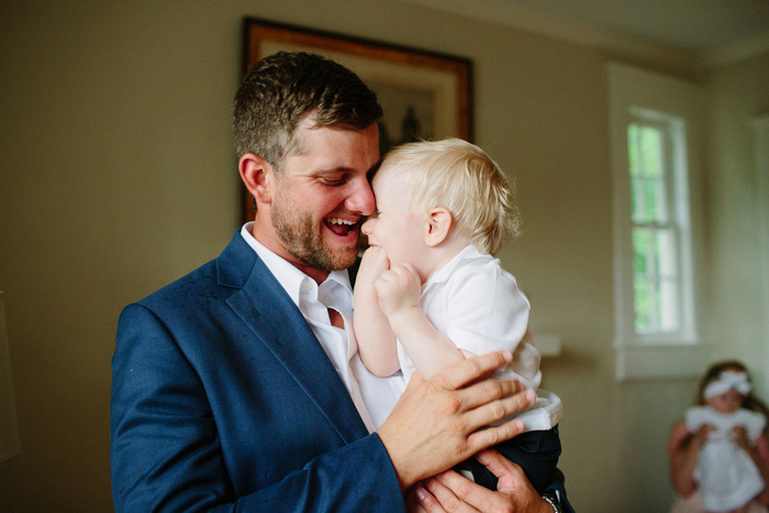 groom laughing with baby son