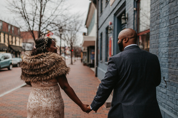 bride and groom walking down street holding hands