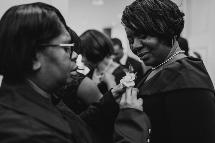 boutonniere being pinned onto dress