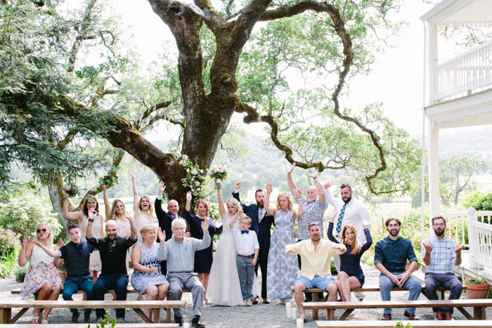 bride and groom posing for photo with all their guests after ceremony