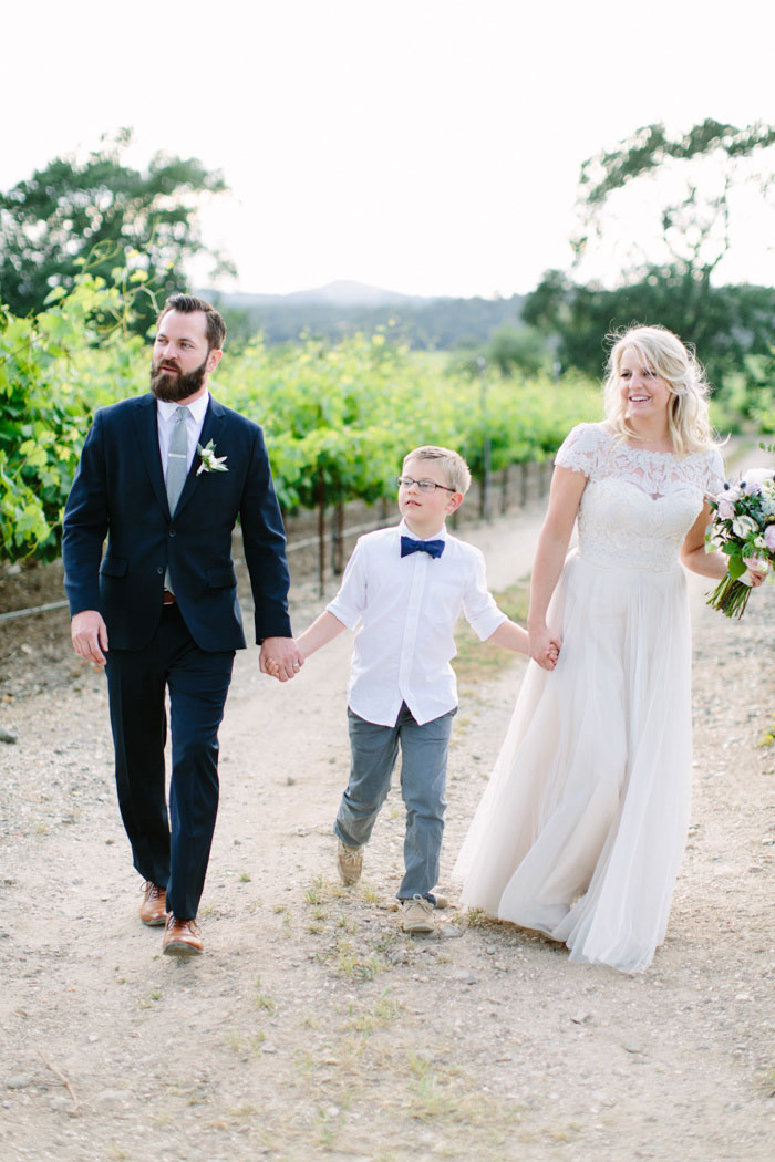 bride, groom and son, walking down dirt road