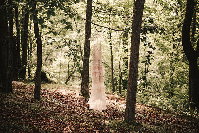 wedding dress hanging in the woods