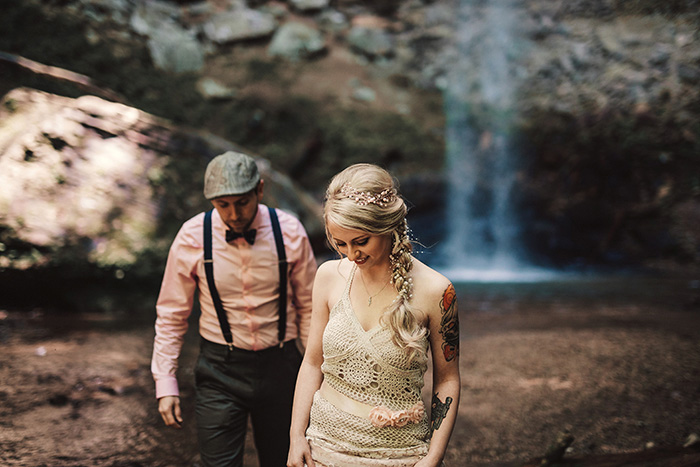 bride and groom by waterfall