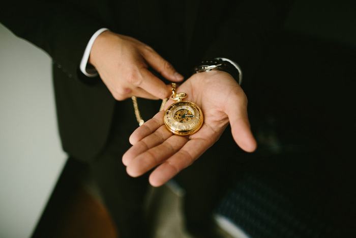 gold pocket watch in groom's hand