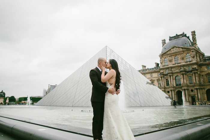 Bride and Groom kissing in front of the Louvre