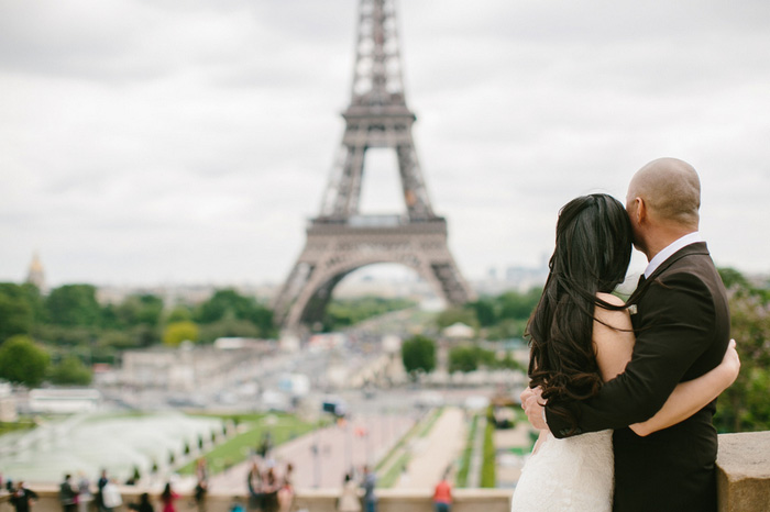 bride and groom looking at the eiffel tower