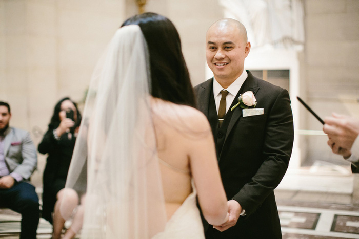 groom grinning at bride during ceremony