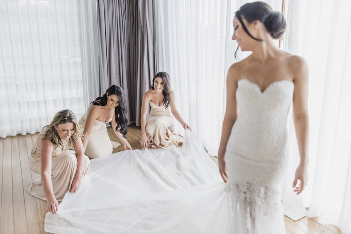 bridesmaids helping bride get dressed