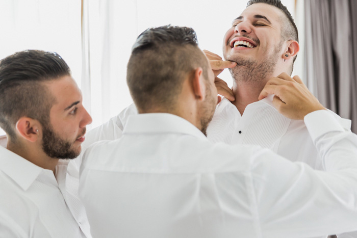 groomsmen helping groom get ready