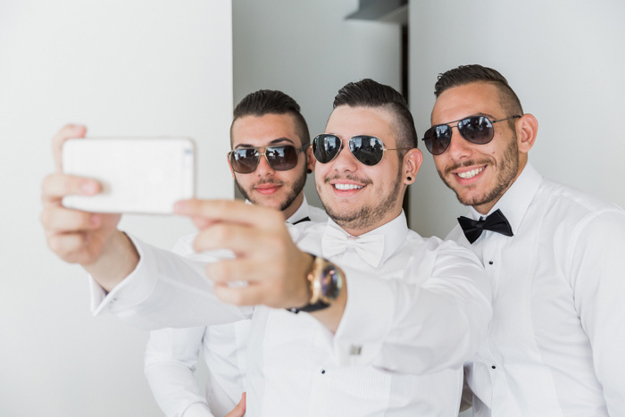 groom taking selfie with his groomsmen