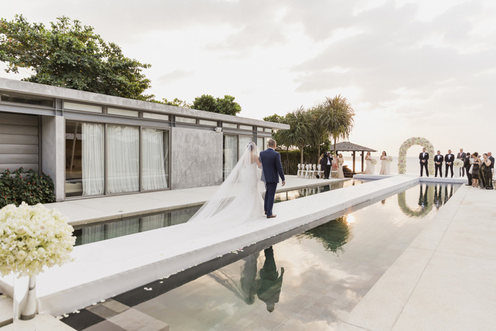 bride walking down aisle set up over water