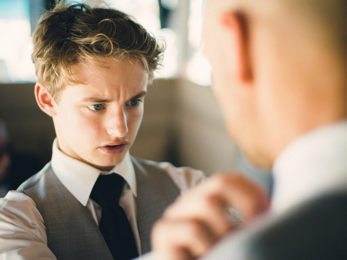 son helping groom with his tie