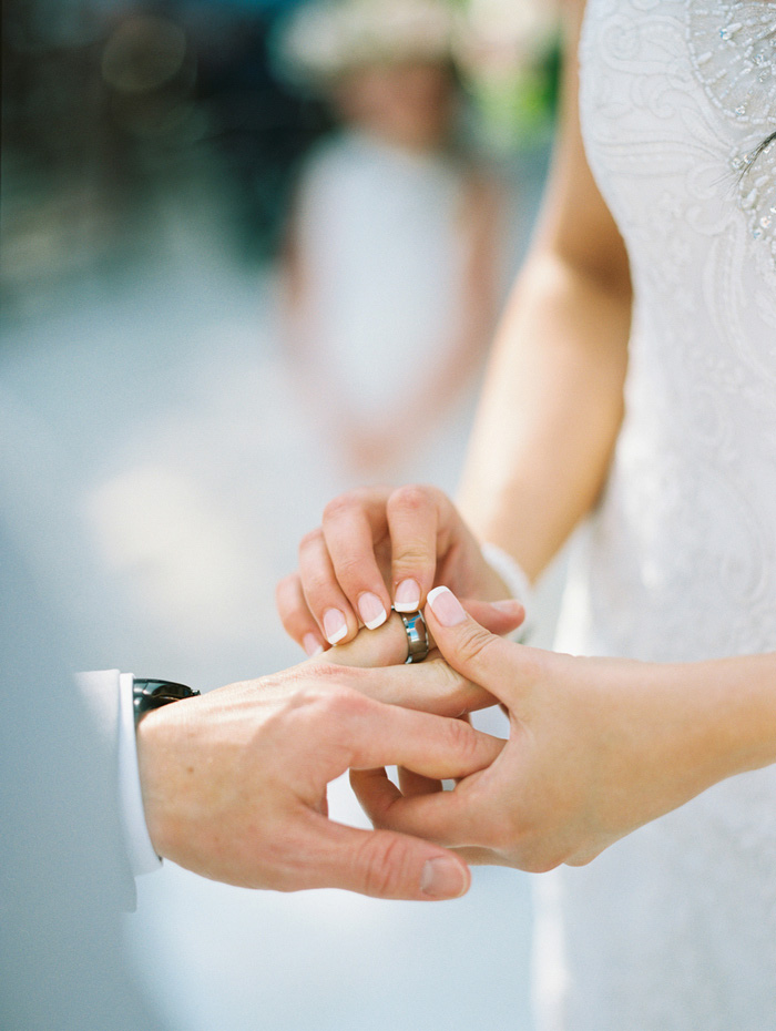 bride putting ring on groom's finger