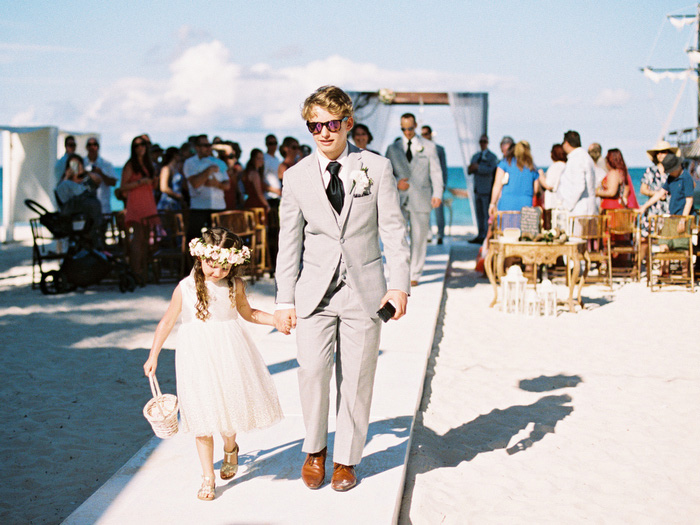 flower girl and groomsman walking down aisle