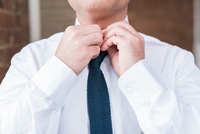 groom adjusting tie