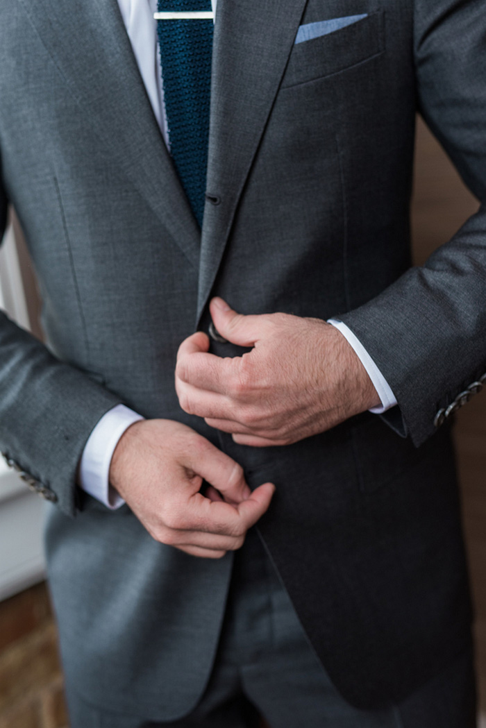 groom buttoning jacket